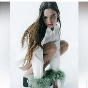 Zara white shirt with green feather sleeves.